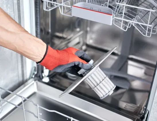 handyman-holding-dishwasher-filter-open-dishwasher
